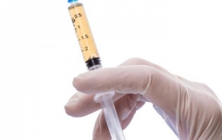 Syringe with vaccine in human hand isolated on white background