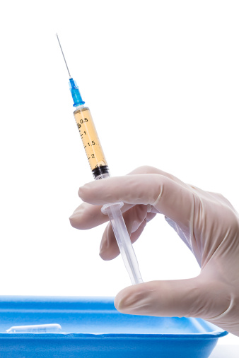 Syringe with vaccine in human hand isolated on white background